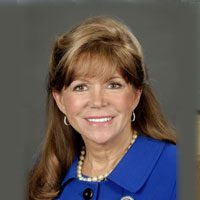 A woman with long hair and blue jacket.