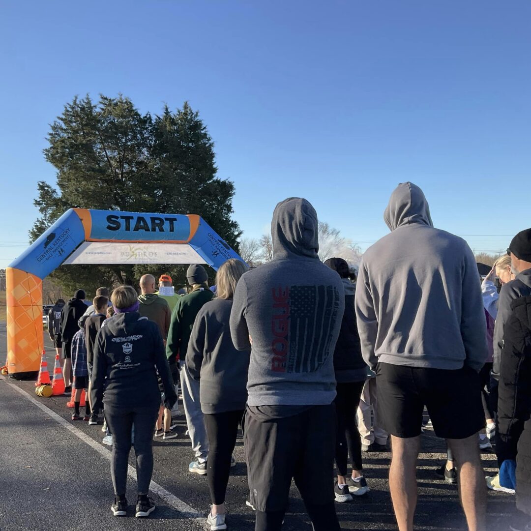 A group of people standing in front of an orange and blue arch.