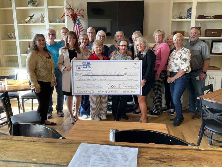 A group of people posing for a picture with a check.