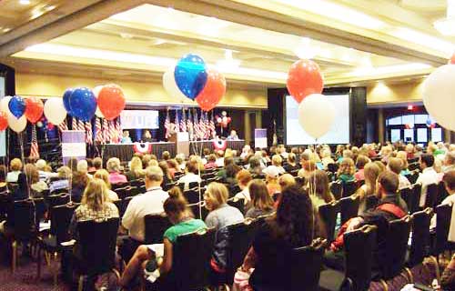 A crowd of people sitting in chairs at an event.