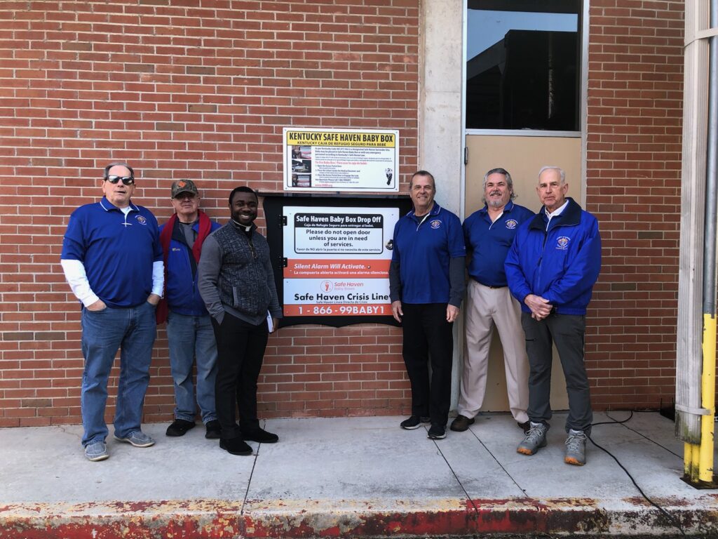 A group of men standing in front of a brick building.